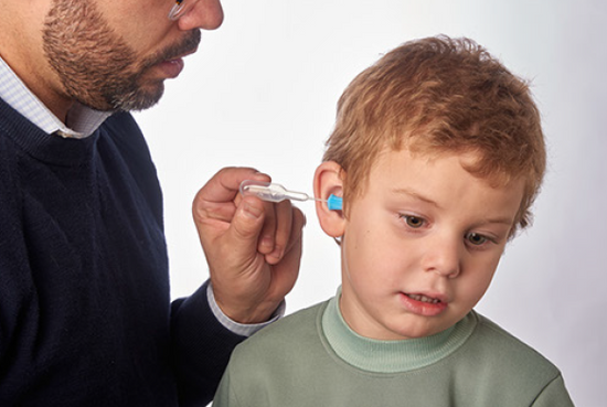 Physician administering prescription ear drops to a child using ClearDropper's applicator